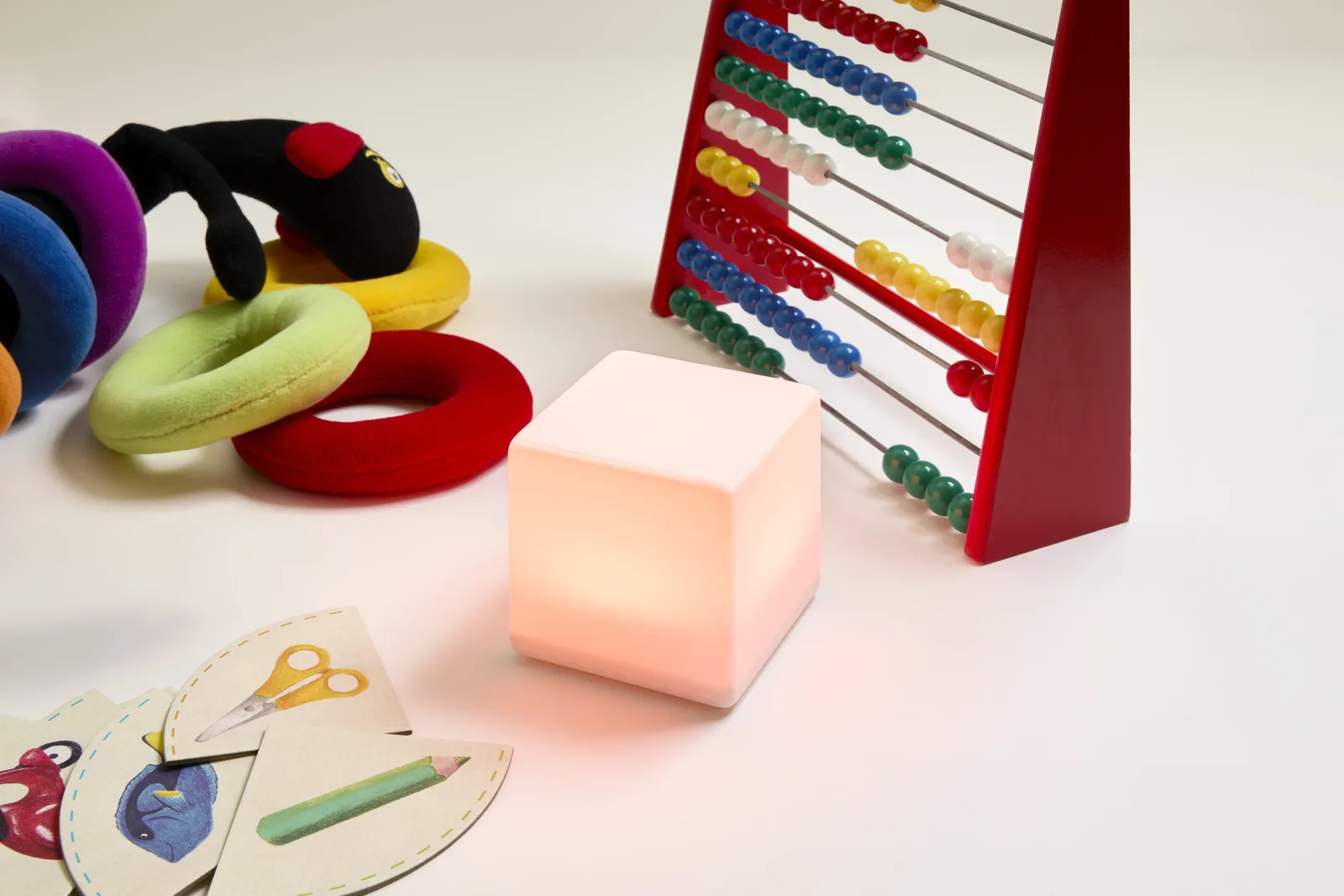 Un cube LittleCubes orange entouré de jeux éducatifs