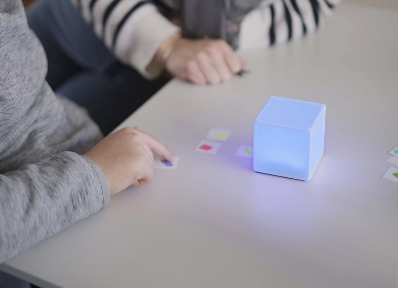 Un enfant utilise un cube LittleCubes lumineux pendant une activité